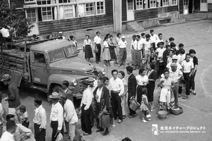 老若男女問わずバケツを持った人たちが、一台の車の周りをぐるっと囲んで並んでいる。