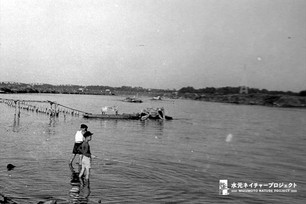 少年が二人、江戸川の浅瀬に立って釣りをしている。